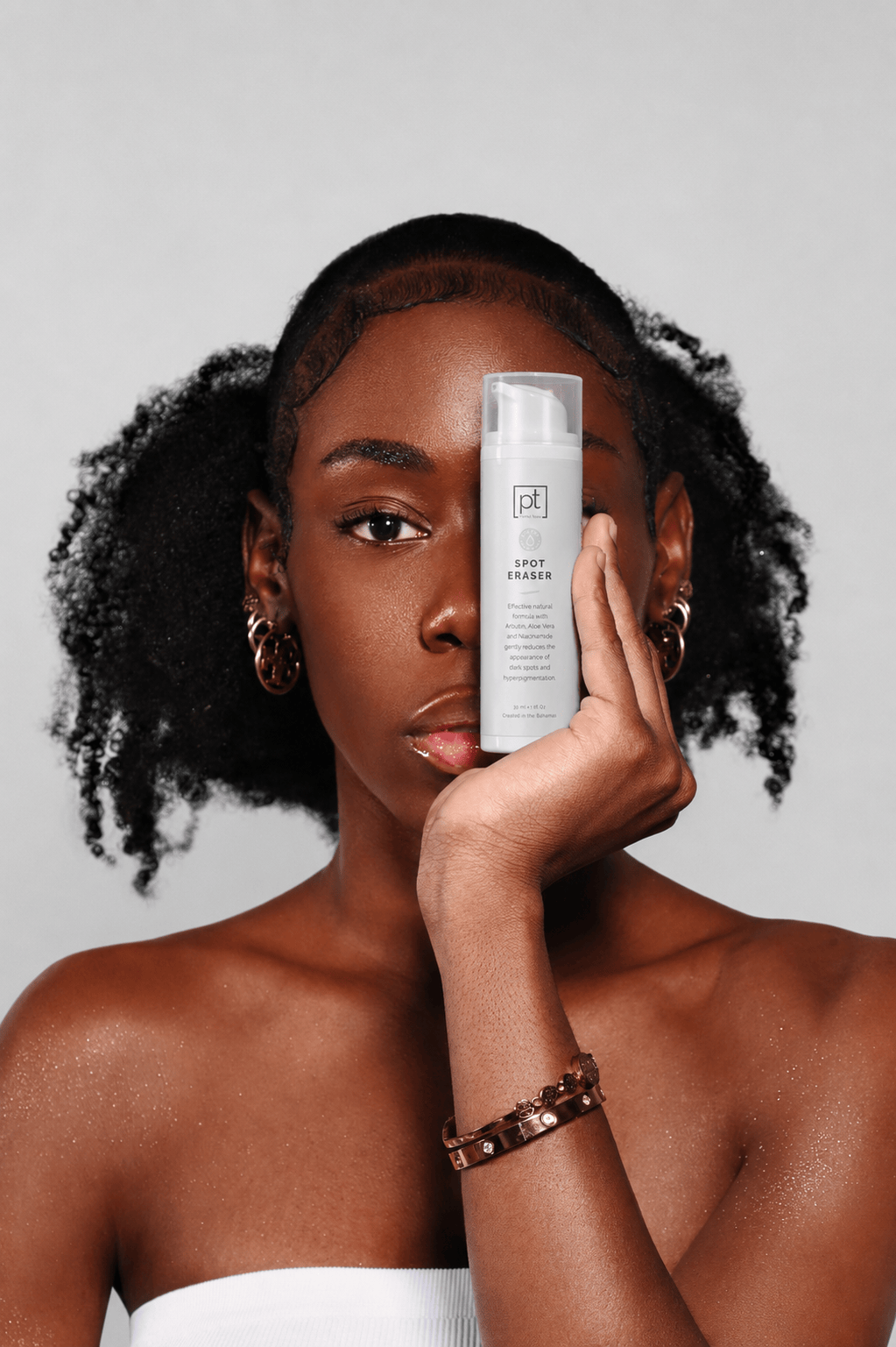 Woman holding Perfec-Tone Spot Eraser, an arbutin serum for dark spots